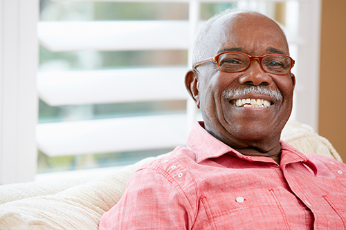 Senior african american man sitting on a couch smiling